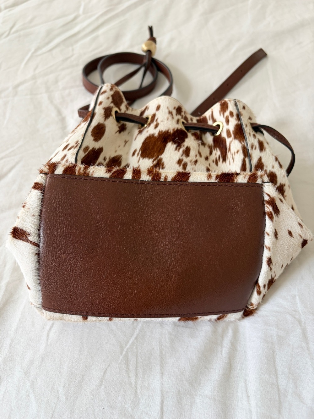 The Mini Drawstring Crossbody Bucket Bag Cow Print - Picture 8 of 11